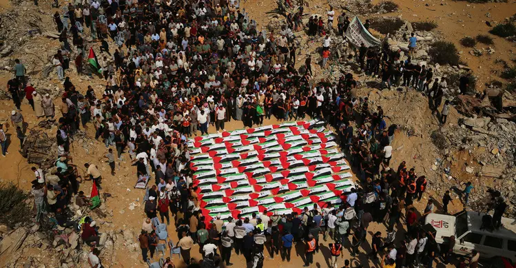 Warga Palestina berkumpul di sekitar jenazah warga Palestina yang tewas dalam serangan Israel selama perang dengan Hamas setelah ditemukan dari bawah reruntuhan bangunan, dalam prosesi pemakaman di Kota Gaza, Kamis (1/10/2026). Jenazah yang ditutupi bendera Palestina tersebut diiringi keluarga dan warga dalam suasana duka. (AP Photo/Yousef Al Zanoun)