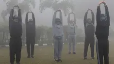 Sejumlah pria melakukan pemanasan saat berolahraga di tengah kabut tebal dan polusi udara di Amritsar, India (2/1). (AFP Photo/Narinder Nanu)