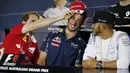 Pebalap Ferrari, Sebastian Vettel (kiri), bercanda dengan pebalap Red Bull, Daniel Ricciardo (tengah), saat konferensi pers jelang F1 GP Australia di Sirkuit Albert Park, Australia, Kamis (17/3/2016). (Reuters/Brandon Malone)