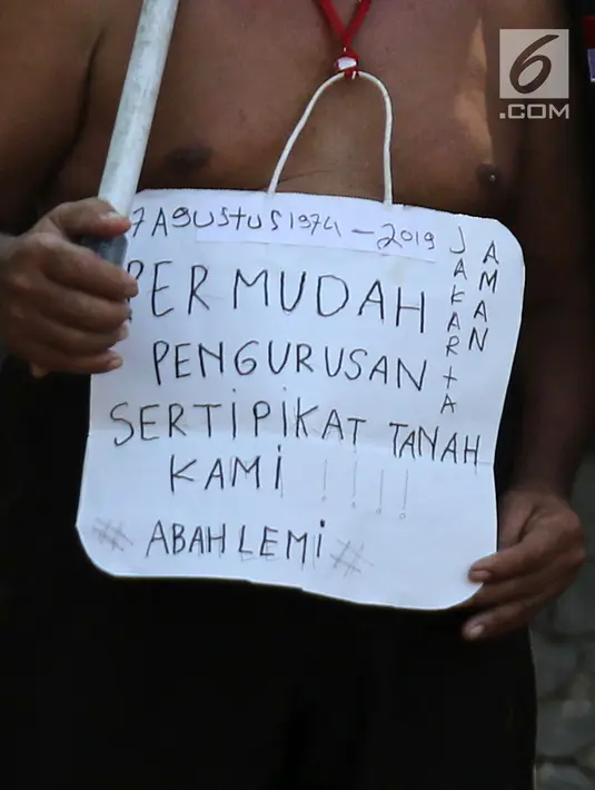 Warga yang tergabung dalam Aliansi Tanah Untuk Rakyat membawa poster aksi kubur diri di Taman Kayu Mas, Pulogadung, Jakarta Timur, Jumat (23/8/2019). Mereka menuntut  BPN Jakarta Timur mempercepat proses pengukuran dan melawan mafia tanah. (Liputan6.com/Herman Zakharia)