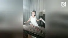 Seorang gadis berusia 9 tahun piawai bermain 2 alat musik sekaligus. Ia memainkan piano dan kecapi China  secara bersamaan.