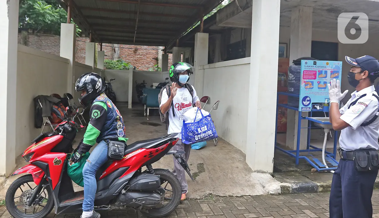 Pasien sembuh COVID-19 berpamitan dengan petugas keamanan saat meninggalkan ruangan isolasi Graha Wisata Ragunan di Jakarta, Jumat (29/1/2021). Sebanyak 68 pasien covid-19 dari total 81 pasien yang melakukan isolasi di tempat itu telah dinyatakan sembuh. (Liputan6.com/Herman Zakharia)