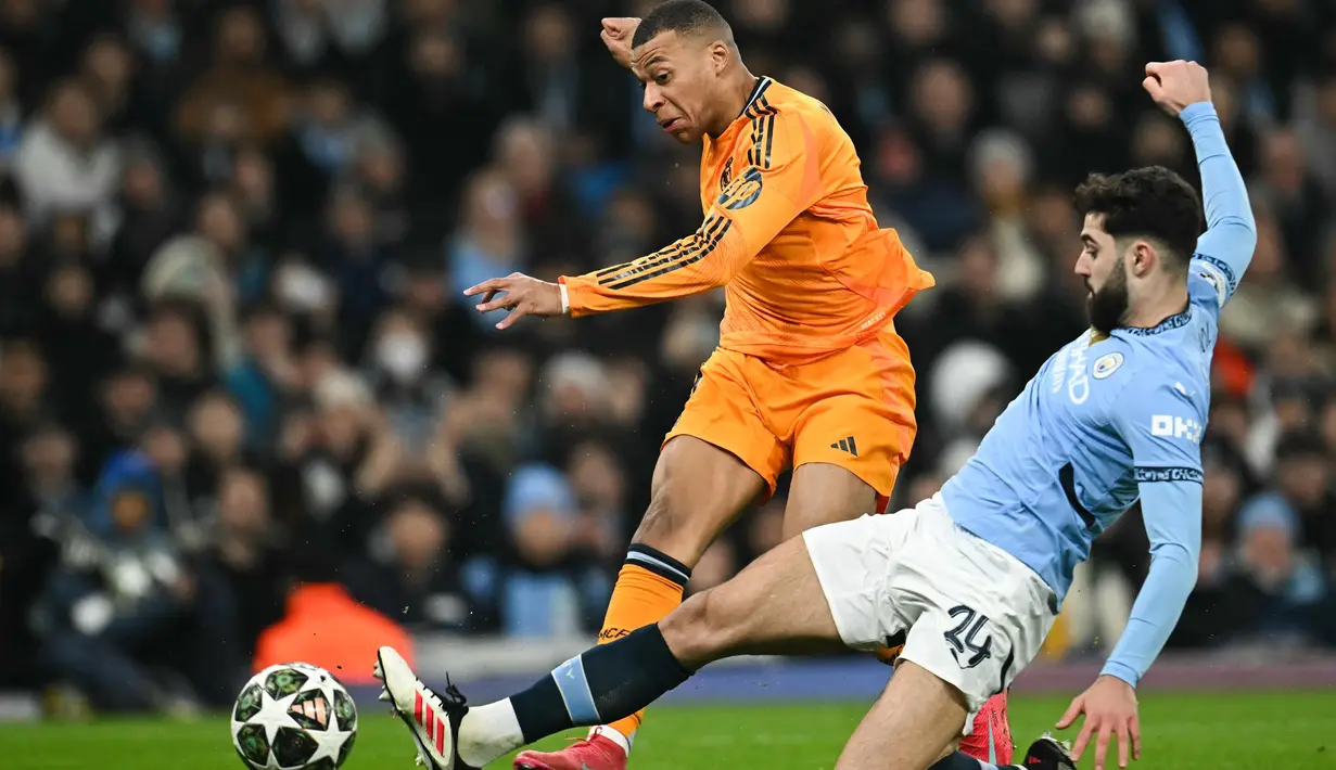 Di babak kedua, Real Madrid bermain lepas dan mengatur tempo permainan. Hasilnya, pada menit ke-60 tendangan terarah Kylian Mbappe berhasil menjebol gawang Manchester City. Skor imbang 1-1. (Paul ELLIS/AFP)