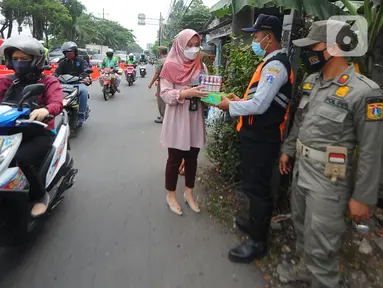 Pegawai PT Bank Tabungan Negara (BTN) membagikan makanan dan hand sanitizer kepada petugas yang menjaga area penyekatan di kawasan Samsat Daan Mogot, Jakarta, Kamis (22/07/2021). Bantuan BTN Peduli pada PPKM Darurat membantu petugas menekan dan meminimalisasi penularan Covid-19. (Liputan6.com) 