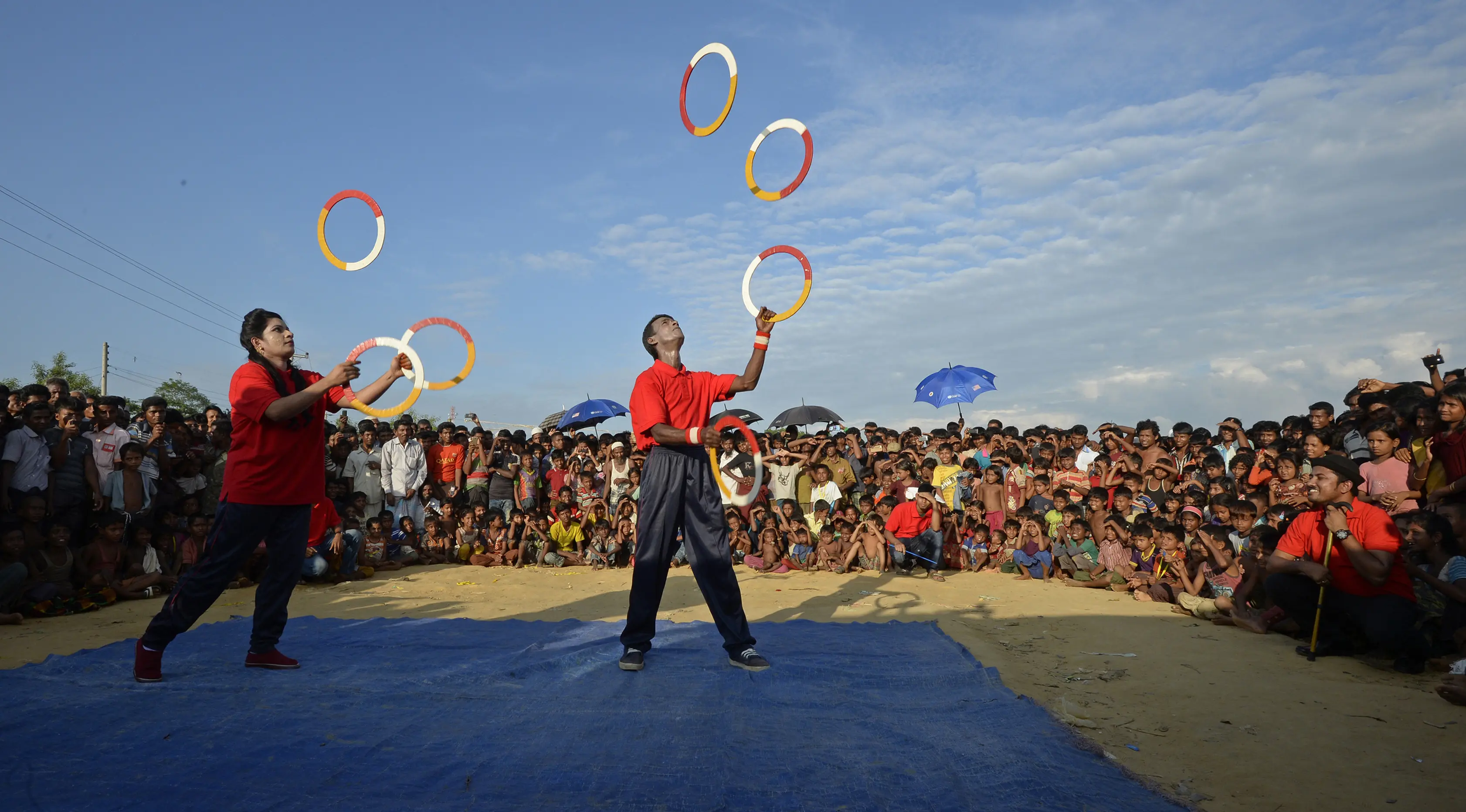 Kelompok teater Drama Therapy melakukan atraksi untuk menghibur anak-anak pengungsian Rohingya di kamp pengungsi Kutupalong, Bangladesh (28/10). (AFP Photo/Tauseef Mustafa)