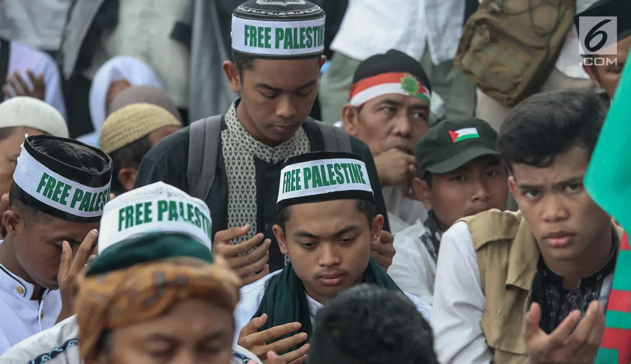 Peserta Aksi Bela Palestina berdoa di kawasan silang Monas, Jakarta, Minggu (17/12). Aksi ini juga dihadiri Ketua Umum MUI Ma'ruf Amin, hadir juga Ketua MPR RI Zulkifli Hasan dan Menteri Agama Lukman Hakim Saifuddin. (Liputan6.com/Faizal Fanani)