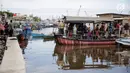 ejumlah warga menggunakan transportasi perahu eretan di kawasan kampung Akuarium, Jakarta, Minggu (12/11). Perahu eretan ini memudahkan warga yang tinggal di wilayah Luar Batang untuk menyeberang menuju kampung Akuarium. (Liputan6.com/Faizal Fanani)