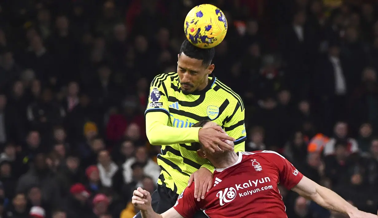 Pemain Arsenal, William Saliba, duel udara dengan pemain Nottingham Forest, Chris Wood, dalam laga Premier League 2023/2024 pekan 22 di Stadion City Ground, Rabu (31/1/2024). Arsenal menang dengan skor 2-1. (AP Photo/Rui Vieira)