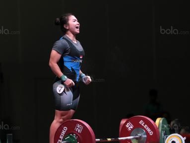 Teriakan Dewi Safitri saat ssebelum mengangkat beban pada kelas 53 kg di Hall A Arena Pekan Raya Jakarta, Kemayoran, Rabu (11/2/2018). Dewi Safitri menang dengan total angkatan 184 kg. (Bola.com/Nicklas Hanoatubun)