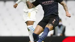 Bek Manchester City, Kyle Walker berebut bola dengan pemain Marseille, Jordan Amavi pada pertandingan grup C Liga Champions di Stade Velodrome di Marseille, Prancis, Selasa (27/10/2020). City menang telak 3-0 atas Marseille. (Guillaume Horcajuelo/Pool via AP)