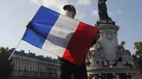 Seorang demonstran memegang bendera Prancis dengan slogan "Freedom of Speech" selama demonstrasi di Paris (18/10/2020). Pembunuh Samuel merupakan pria kelahiran Moskow berusia 18 tahun yang ditembak mati oleh polisi. (AP Photo/Michel Euler)