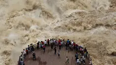 Wisatawan menikmati pemandangan mengerikan derasnya arus sungai Jinsha dari tempat wisata Tiger Leaping Gorge di Diqing, Provinsi Yunnan, China (15/7). (REUTERS / Stringer)