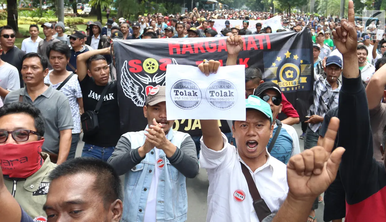 Sejumlah demonstran membawa poster saat menggelar aksi di depan Kantor Kementrian Perhubungan, Jakarta Pusat, Senin (29/1). Permenhub tersebut  soal Kendaraan Bermotor Umum Tidak Dalam Trayek. (Liputan6.com/Angga Yuniar)