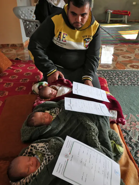 Pasangan Nidal dan Islam Al-Saiqli berpose dengan bayi kembar mereka, Jerusalem, Capital dan Palestine di Khan Yunis, Jalur Gaza, Jumat (2/2). Nama unik itu untuk memprotes Donald Trump yang mengklaim Yerusalem sebagai ibu kota Israel (SAID KHATIB/AFP)