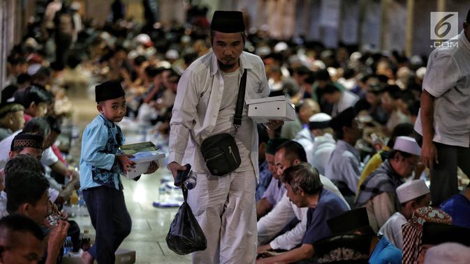 Umat muslim membawa nasi kotak saat mengikuti buka puasa bersama di Masjid Istiqlal, Jakarta, Senin (6/5/2019). Menu berbuka puasa di Masjid Istiqlal setiap harinya selalu berubah. (Liputan6.com/Faizal Fanani)