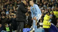 Pelatih Manchester City, Pep Guardiola memberi instruksi kepada Erling Haaland sebelum memasuki lapangan sebagai pemain pengganti saat menghadapi Burnley pada laga pekan ke-22 Premier League 2023/2024 di Etihad Stadium, Manchester, Rabu (31/1/2024). (AP Photo/Dave Thompson)