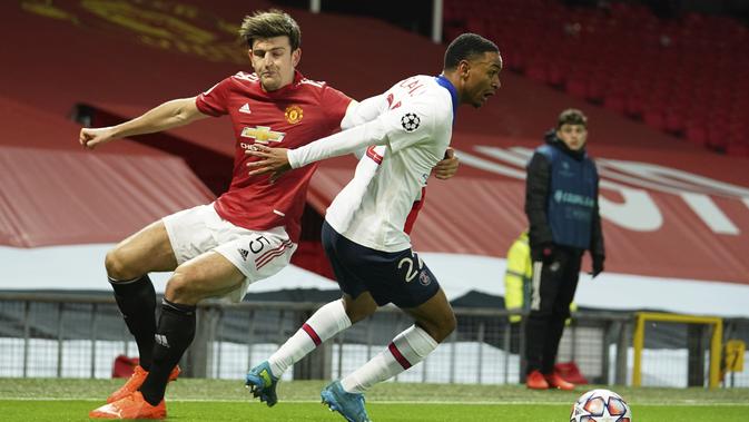 Gelandang Manchester United atau MU, Harry Maguire berebut bola dengan bek Paris Saint Germain (PSG), Abdou Diallo saat berebut bola pada matchday kelima Grup H Liga Champions di Stadion Old Trafford, Kamis (3/12/2020) dinihari WIB. MU keok 1-3 dari PSG. (AP Photo/Dave Thompson)