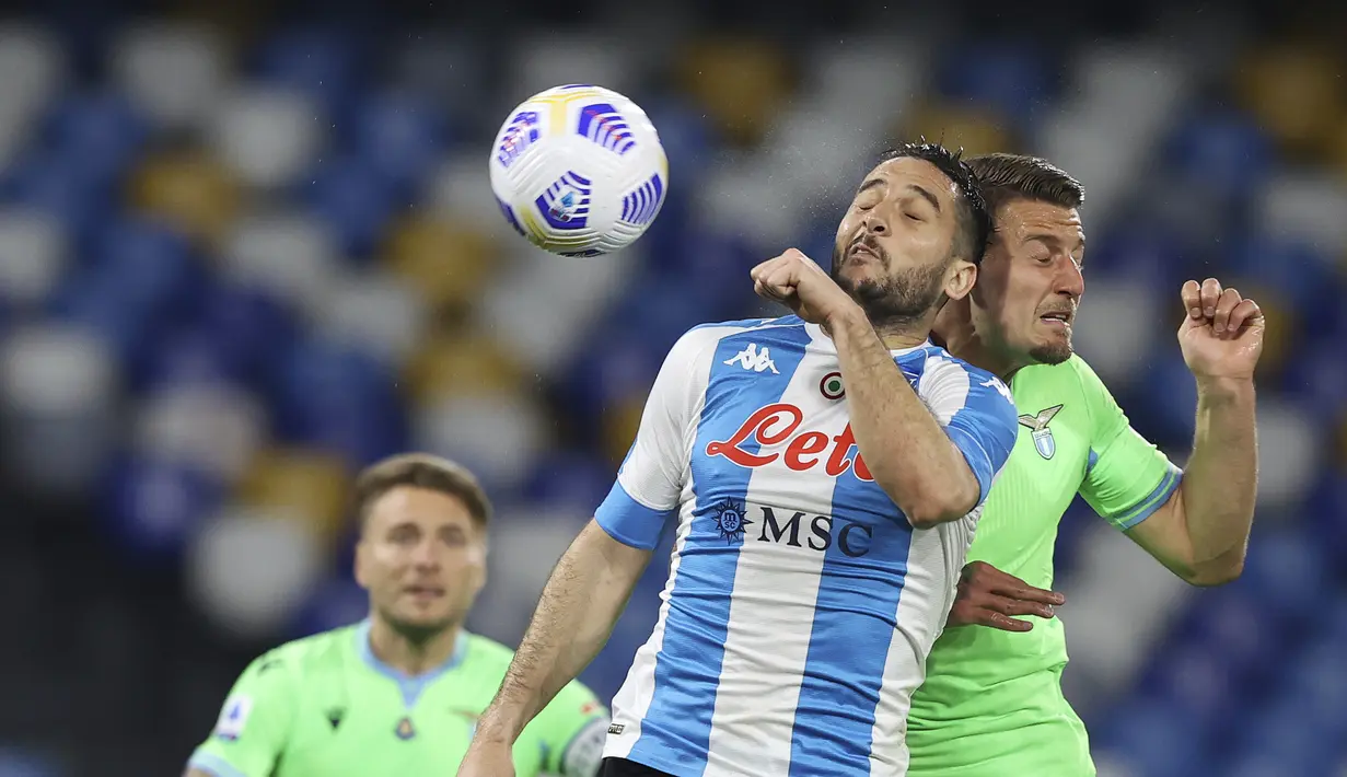 Bek Napoli, Konstantinos Manolas berebut bola udara dengan gelandan Lazio, Sergej Milinkovic-Savic pada pertandingan  Liga Serie A Italia di Stadion San Paolo, Italia, Jumat (23/4/2021). Napoli menang telak atas Lazio 5-2. (Alessandro Garofalo/Lapresse via AP)