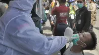 Wisatawan melakukan tes cepat (rapid test) Antigen COVID-19 di kawasan Pasar Cisarua, Bogor, Jumat (12/2/2021). Tes cepat antigen oleh petugas gabungan Satgas Covid-19 itu dilakukan secara acak untuk antisipasi penyebaran COVID-19 dari wisatawan di kawasan Puncak Bogor. (merdeka.com/Arie Basuki)