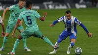 Pemain Espanyol, Raul de Tomas, berusaha melewati pemain Real Madrid, Raphael Varane, pada laga La Liga di Stadion Cornella-El Prat, Minggu (28/6/2020). Real Madrid menang 1-0 atas Espanyol. (AP/Joan Monfort)
