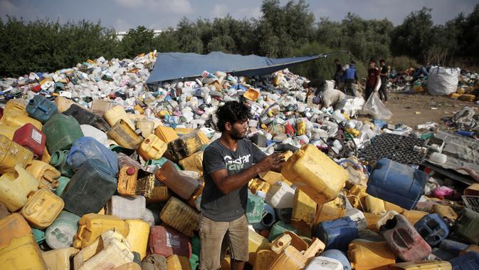 Pengumpul sampah Palestina menimbun jeriken sambil memilah-milah sampah di tempat pembuangan sampah di Gaza (29/7/2019). Kemiskinan yang terjadi akibat blokade Israel dan kurangnya kesempatan kerja membuat beberapa warga Palestina memilih bekerja mencari sampah untuk dijual. (AFP Photo/Mohammed)