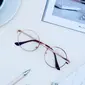 Kacamata dengan frame oval untuk kesan tampilan yang lembut (unsplash/jess bailey).