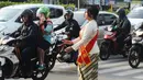 Personel Polisi Wanita (Polwan) Polres Jakarta Timur mengenakan pakaian kebaya saat mengatur arus lalu lintas di Jalan Otista Raya, Jatinegara, Jumat (20/4). Para polwan itu juga mengenakan selempang bertulisan Polres Jaktim. (Merdeka.com/Imam Buhori)