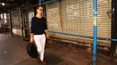 Seorang wanita berjalan di depan sebuah toko yang tutup di West Village, New York (11/4). Bisnis online shop yang terus berkembang membuat sejumlah toko gulung tikar karena sewa yang naik. (Spencer Platt / Getty Images / AFP)