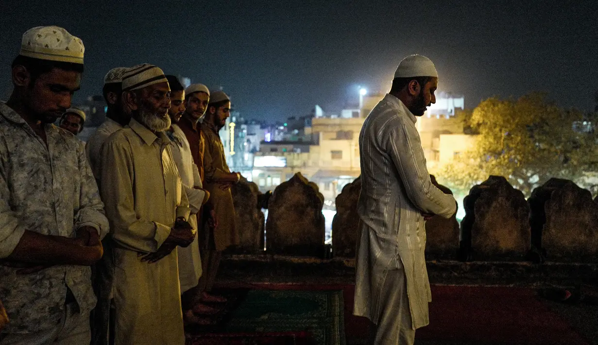 Umat muslim India menjalankan salat tarawih selama bulan suci Ramadan di Masjid Jama di New Delhi, India (23/5). Seperti jutaan muslim di seluruh dunia, muslim India juga menjalankan salat Terawih pada malam bulan Ramadan. (AFP/Chandan Khanna)