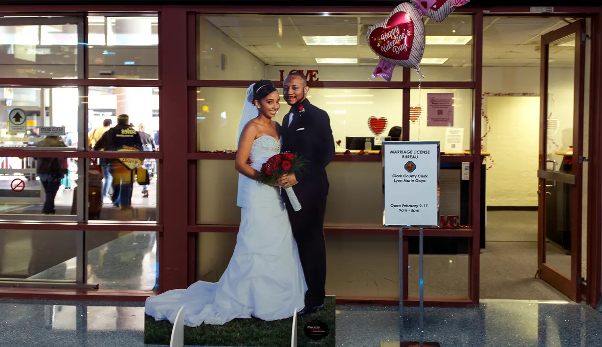 Baner sepasang pengantin dipajang di depan kantor Clark County Clerk's yang melayani jasa layanan untuk pernikahan di Bandara Internasional McCarran di Las Vegas (12/2). Las Vegas dikenal sebagai ibu kota pernikahan dunia. (AFP/L.E. Baskow)