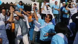 Menteri KKP, Susi Pudjiastuti berjoget baby shark dance saat meresmikan 'Pandu Laut Nusantara', Jakarta, Minggu (15/7). Tiupan terompet Kaka Slank dan pemberian syal oleh Susi menjadi tanda Pandu Laut Nusantara diresmikan.  (Liputan6.com/Arya Manggala)