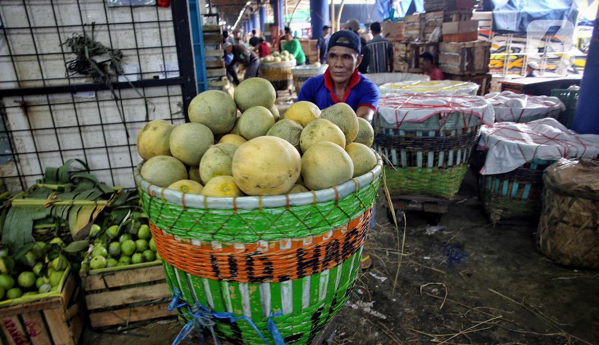 Pedagang mendorong gerobak berisi buah segar yang akan di jual di pasar Kramat Jati, Jakarta, Kamis (13/3/2025). (Liputan6.com/Angga Yuniar)