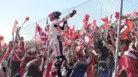 Juara dunia MotoGP 2016, Marc Marquez, merayakan kemenangan di depan pendukungnya setelah berhasil finis kedua dalam balapan MotoGP Valencia di Sirkuit Ricardo Tormo, Minggu (13/11/2016). (AFP/Jose Jordan)
