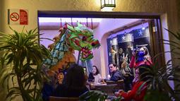 Anggota komunitas Tionghoa di Meksiko menampilkan tarian naga tradisional (liong) di sebuah restoran Tiongkok menyambut Tahun Baru Imlek di Mexico City, pada 31 Januari 2022. Tahun Baru Imlek 2022 menandai dimulainya tahun Shio Macan Air. (PEDRO PARDO / AFP)