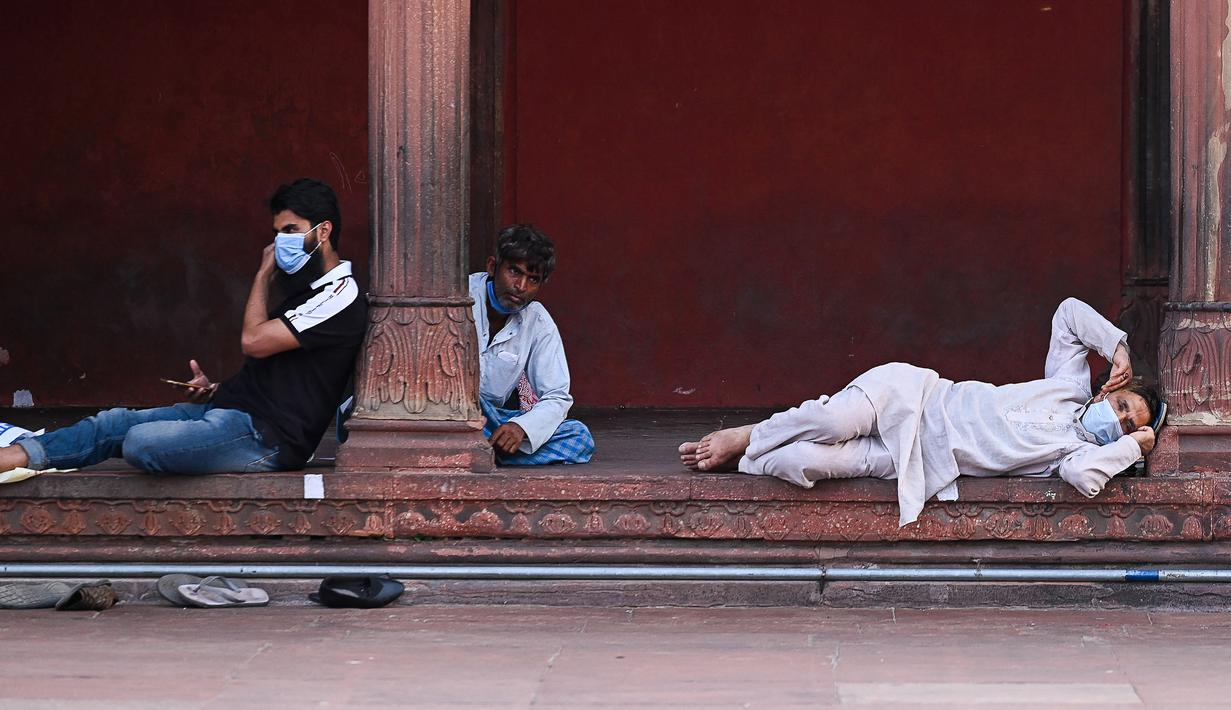 Umat Muslim menunggu di masjid Jama Masjid sebelum berbuka puasa pada hari pertama bulan suci Ramadhan, di New Delhi (14/4/2021). Masjid Jama atau Masjid-i Jahān-Numā merupakan masjid utama yang berada di kawasan Delhi Tua di India. (AFP/Prakash Singh)