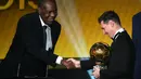 Lionel Messi menerima trofi FIFA Balon d'Or 2015 dari Presiden interim FIFA, Issa Hayatou, dalam acara di Kongresshaus, Zurich, Swiss, Selasa (12/1/2016) dini hari WIB. (AFP/Olivier Morin)