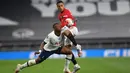 Winger Tottenham Hotspur, Steven Bergwijn berebut bola dengan striker Manchester United, Mason Greenwood dalam laga Liga Inggris di Stadion Tottenham, London, Jumat (19/6/2020). Manchester United berhasil mencuri poin di markas Hotspur dengan skor imbang 1-1.  (AP/Glyn Kirk, Pool)