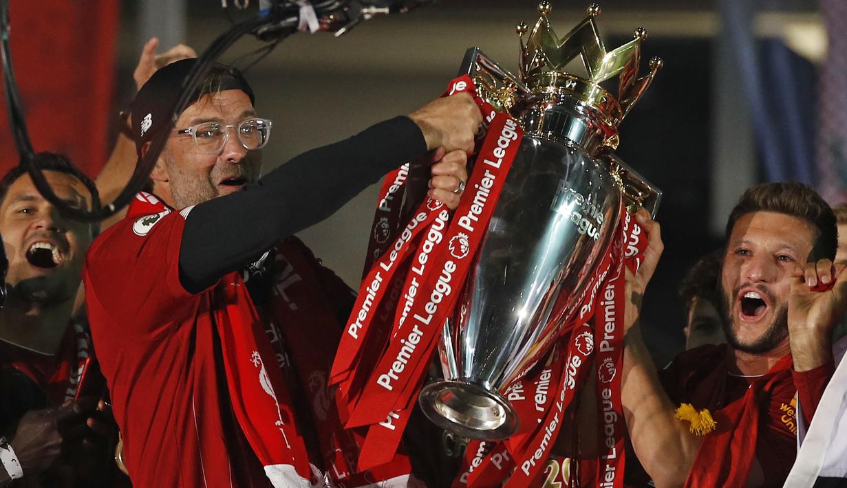 Pelatih Liverpool, Jurgen Klopp, mengangkat trofi juara Premier league 2019-2020 di Stadion Anfield, Kamis (23/7/2020) dini hari WIB. Prosesi angkat trofi juara ini dilakukan usai pertandingan Liverpool melawan Chelsea. (AFP/Phil Noble/pool)