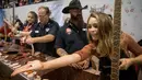 Miss Texas Margana Wood menujukkan hati ular derik kepada pengunjung saat acara Swingter Rattlesnake Sweetwater di Nolan County Coliseum (10/3). Tradisi ini dianggap sebagai peredam populasi ular derik yang kian terlalu banyak. (AFP/Loren Elliot)