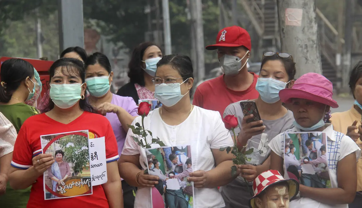 Warga membawa bunga mawar sebagai penghormatan kepada seorang guru yang tewas dalam protes kudeta militer di Yangon, Myanmar, Senin (1/3/2021).  Seorang guru perempuan tewas setelah polisi melemparkan granat setrum untuk membubarkan aksi protes yang digelar para guru di Yangon. (AP Photo)