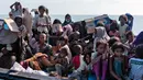 Pengungsi etnis Rohingya duduk di atas kapal saat mereka tiba di pesisir pantai Lancok, di Kabupaten Aceh Utara, Kamis (25/6/2020). Nelayan Indonesia menemukan hampir 100 orang etnis Rohingya, termasuk 30 orang anak-anak terdampar di tengah laut dengan kondisi kapal rusak. (AP Photo/Zik Maulana)