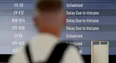 Salah satu calon penumpang melihat papan elektronik yang menampilkan penerbangan yang dibatalkan di Bandara Internasional Ngurah Rai, Tuban, dekat Denpasar, Bali, pada 21 Maret 2025. (SONNY TUMBELAKA/AFP)