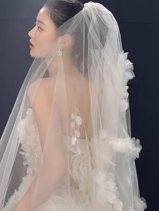 Melengkapi tampilannya dengan veil panjang yang terbuat dari bahan yang sama dihiasi dengan hiasan kelopak kecil. [@you_r_love]