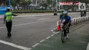 Polisi menghalau pesepeda yang berada di luar jalur di kawasan Sudirman-Thamrin, Jakarta Pusat, Rabu (2/6/2021). Sepeda road bike diperbolehkan untuk melintas di Jalan Sudirman-Thamrin pada hari kerja Senin-Jumat, namun dibatasi dari pukul 05.00-06.30 WIB. (Liputan6.com/Faizal Fanani)