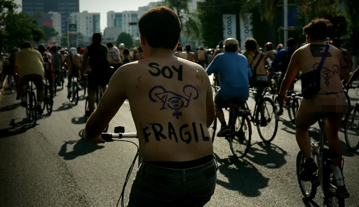 Seorang pria yang badannya di cat mengendarai sepeda saat mengikuti World Naked Bike Ride di Guadalajara, Jalisco, Meksiko (17/6). Mereka memprotes gas emisi dari mobil dan prilaku agresif supir di wilayah tersebut. (AFP Photo/Hector Guerrero)