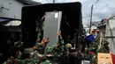 Personel TNI AD saat mengangkat barang milik warga ke atas truk ketika pembebasan Asrama Batalyon Siliwangi di Cililitan, Jakarta Timur, Kamis (8/1/2015). (Liputan6.com/Johan Tallo)
