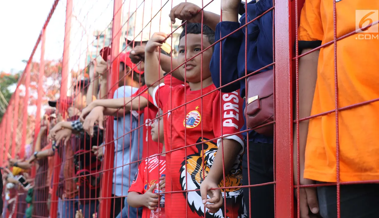 Suporter tim Macan Kemayoran menyaksikan latihan perdana Persija pasca menjuarai Liga 1 musim 2018 di Lapangan Wisma Aldiron, Jakarta, Senin (7/1). 30 pemain ikut dalam latihan perdana yang digelar terbuka. (Liputan6.com/Helmi Fithriansyah)