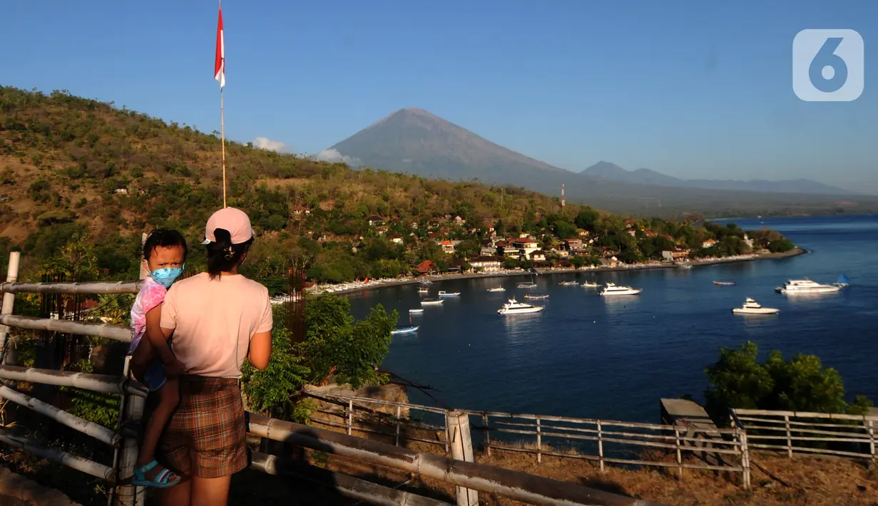 Wisatawan menikmati pemandangan di kawasan Pantai Amed, Bali, Jumat (3/9/2021). Sepinya wisatawan yang datang ke Pulau Bali selama PPKM Darurat yakni hanya sebesar rata-rata 500 wisatawan lokal menyebabkan sejumlah tempat wisata pantai sepi pengunjung. (merdeka.com/Arie Basuki)