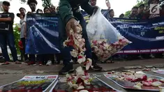 Massa melakukan aksi tabur bunga di depan kantor Komnas HAM, Jakarta Pusat, Rabu (12/12). Aksi tersebut dilakukan oleh Aliansi Mahasiswa & Pemuda (AMP) Indonesia Menolak Lupa untuk memperingati Hari HAM Sedunia pada 10 Desember. (Merdeka.com/Imam Buhori)