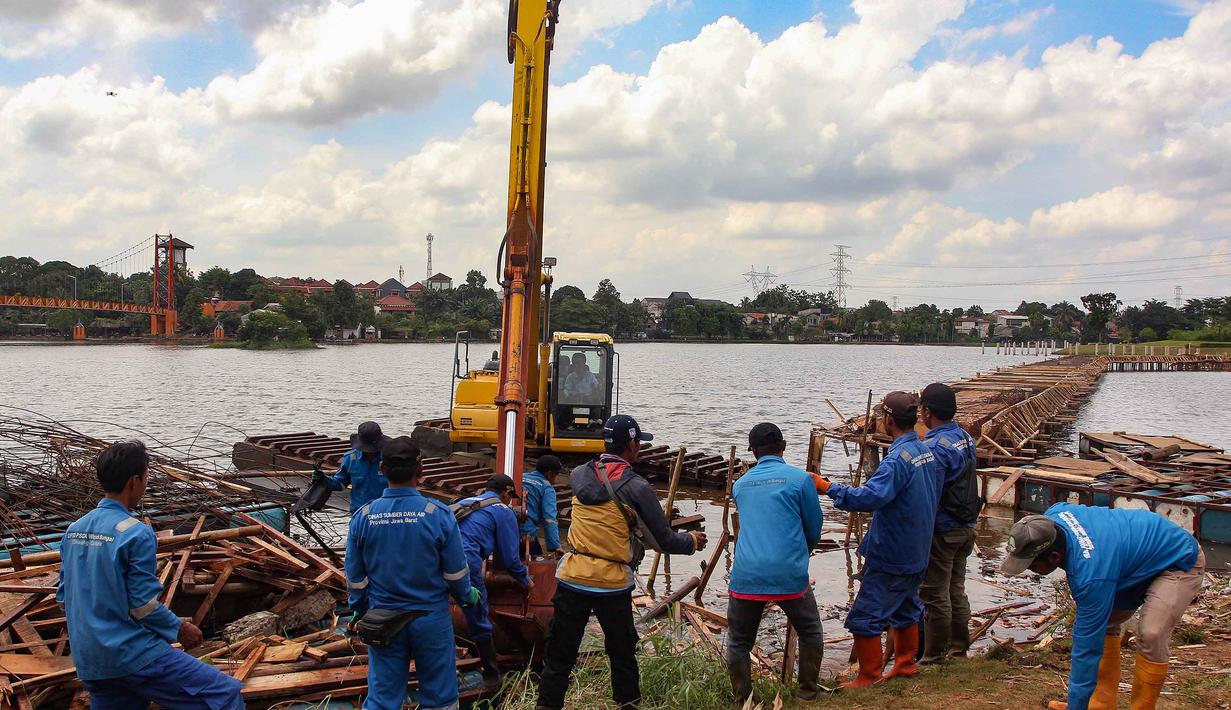 Pembongkaran dilakukan untuk mengembalikan fungsi Setu Tujuh Muara ke kondisi alaminya. Tampak dalam foto, petugas Dinas Sumber Daya Air Pemerintah Provinsi Jawa Barat membongkar tiang pancang beton yang dipasang di Setu Tujuh Muara, Sawangan, Depok, Senin (16/01/2026). (Merdeka.com/Arie Basuki)